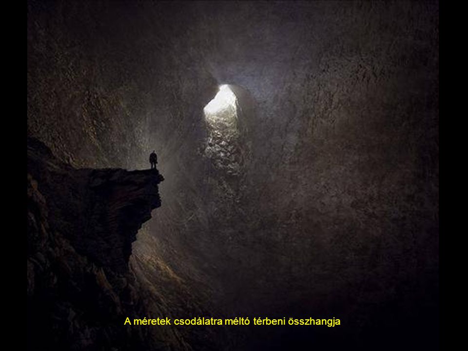 Egy hatalmas fénysugár, vízesés formájában sugározza be a barlangot, a hatalmas stalagmit oszlop mellet eltörpülve, egy barlangász.
